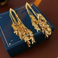 Detailed view of elegant gold leaf tassel earrings on a premium blue jewelry box - Silver Needle Gold Plated Tassel Style / Gold