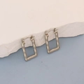 Detailed view of silver rectangular bamboo textured hoop earrings on a stone display - Silver Rectangular Bamboo Hoop