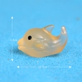 Glow-in-the-dark yellow resin dolphin figurine measuring 2.6cm long and 1.6cm high - Orange