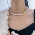 Elegant pearl necklace with a cute yellow duck charm worn by a model in a trendy style - Playful Yellow Duck Pendant Artificial Pearl Necklace (X1828B)