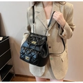 Détail du sac à dos en cuir matelassé noir avec chaîne dorée et fermoir rotatif - L / Noir