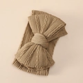 Gros plan détaillé du bandeau bébé en maille kaki avec gros nœud et texture torsadée - Brun Foncé