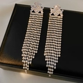 Dettaglio di orecchini vintage in argento con lunghe nappe di zirconi su pelle nera - Argento