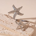 Dettaglio macro dei bracciali a stella marina in argento con texture metallica - Argento