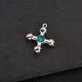 Detailed macro shot of a silver cross pendant featuring a centered green gemstone inlay - Simple Cross Blue