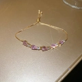 Détail d'un bracelet doré avec zircon rose en goutte et fermoir réglable coulissant - Or-Rose