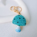 Dettaglio del portachiavi a fungo blu con strass scintillanti e finitura dorata - Fungo Singolo / Blu