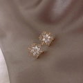 Elegant gold snowflake stud earrings with sparkling crystals on brown silk background - D0009 Snowflake Studs