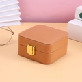 Brown velvet jewelry storage box with golden metal lock and textured leather finish - Tan