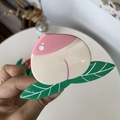 Dettaglio di un fermaglio per capelli in acetato a forma di pesca rosa con foglie verdi - Pesca Rosa Bianco Crema