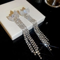 Dettaglio di orecchini a fiocco d'argento con lunghe nappe di strass su un portagioie - Argento (Silver Earring Post)