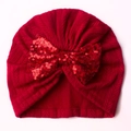 Detailed view of the red infant knit hat with a large sparkling sequin bow on white background - Red