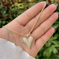 Primo piano del ciondolo a cuore in oro 18K con pavé di zirconi su catena a corda - Stile Cuore Appuntito