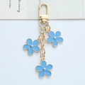 Golden keychain with three blue floral charms and polished five-petal metal design - Light Blue