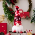 Gnome de Noël rouge avec bonnet en tricot à flocons blancs et étoile sur fond festif - Pose Assise / Rouge