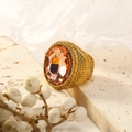 Close-up of pink faceted gemstone ring with textured gold band on stone base - Gold Champagne Stone