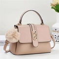 Close-up of pink textured leather handbag with gold hardware and plush pom-pom charm - Khaki