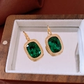 Detailed close-up of emerald square earrings with gold setting in a wooden jewelry box - Emerald Green Ear Buckle (WE1618) / Green