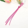Pink braided phone lanyard with black spots and tassels on white background with tulips - Rose Red