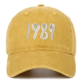 Detailed close-up of white 1989 embroidery on a vintage yellow washed cotton baseball cap - Yellow