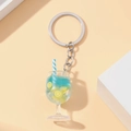 Close-up of blue resin drink keychain with lemon slice, ice cubes and striped straw - Blue