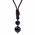 Vue détaillée de trois perles d'obsidienne noire polie sur un cordon tressé marron - Collier Obsidienne-3 Perles