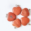 Five red jasper heart pendants with silver bails arranged on a white background - Red Jasper