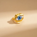 Macro side view of an irregular golden evil eye ring with blue resin eye detail - Gold