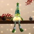 Close-up of a glowing green Christmas gnome doll with star hat on wooden shelf - Long Leg / Green