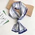 Elegant light blue skinny silk scarf with dark blue geometric border tied on a tray - Woven Chain Navy Blue