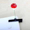 Close-up of red mushroom hair clip with white spots on a green metal stalk detail - Mushroom