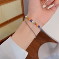 Dettaglio di un bracciale a due strati con perle floreali colorate e catena in metallo - Perline a Fiore Doppio Strato