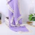 Detail of purple muslin baby blanket showing wrinkled cotton texture and lace tassels - Purple