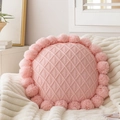Close-up of pink round knit pillow cover featuring diamond texture and pom-pom fringe - Hand Knit Yarn Pillow (With Filling)