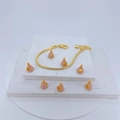 Gold snake chain bracelet featuring pink enamel charms on white stone display - Pink Gold