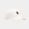 Détail d'une casquette en coton blanc avec patch brodé de la lettre R noire - Blanc