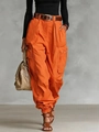 Detail of orange high-waisted cargo pants showing multi-pocket design and woven texture - Orange Red