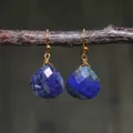 Detail of teardrop blue imperial stone earrings with gold wire wrap on a branch - Dark Blue Faceted Lapis Style (ER1060-2)