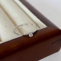 Slanke zilveren ring met textuur en een kleine diamant in een vierpootzetting - US 7 / Zilver