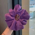Hand holding a large purple chiffon scrunchie showing soft texture and elastic volume - Grape Purple