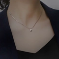 Minimalist silver chain necklace with a Lucky engraved round pendant on model - Plated Platinum Lucky Bead Necklace