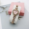 Detail of heart-shaped quartz watch featuring pink teardrop gems and crystal bezel - Rose Gold Pink