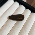 Close-up of brown oval acrylic hair clip with gold France Handmade lettering - Side Duckbill Clip / Black Coffee