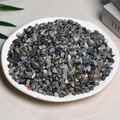 Natural dark grey and black crystal crushed stones in a white plate for decoration - Hawkeye (5-7mm) 100g