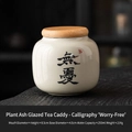 Ceramic mini tea canister with 'Wu You' calligraphy and natural wood lid - Handwritten Calligraphy Straw Ash - No Worries