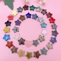 Variety of polished star-shaped crystal stones arranged in a spiral on pink background - Single Star / Mixed Star Shapes