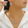 Close-up of elegant silver snowflake jewelry set with crystals and pearls on a model - 24 Earrings + Necklace Style