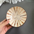 Handmade coconut shell bowl with beige and pink shell mosaic interior held in hand - Brown Stripe Style