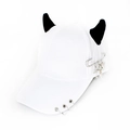 Detail of white baseball cap with black devil horns, metal rings, and safety pin pendant - Safety Pin Snake White