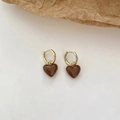 Gros plan détaillé de boucles d'oreilles cœur dorées avec émail marron chocolat - Boucles d'Oreilles Coeur Rétro - Café